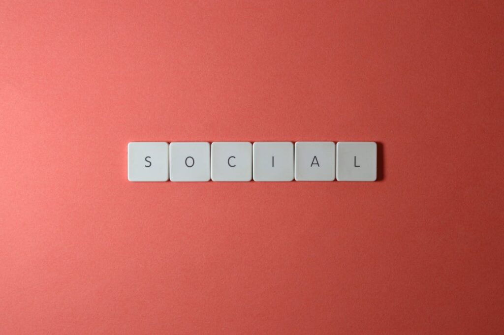 Close-up of the word 'SOCIAL' formed with tiles on a red surface, offering copyspace.